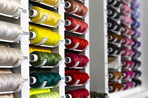 Raws of multi colored sewing threads on a stand